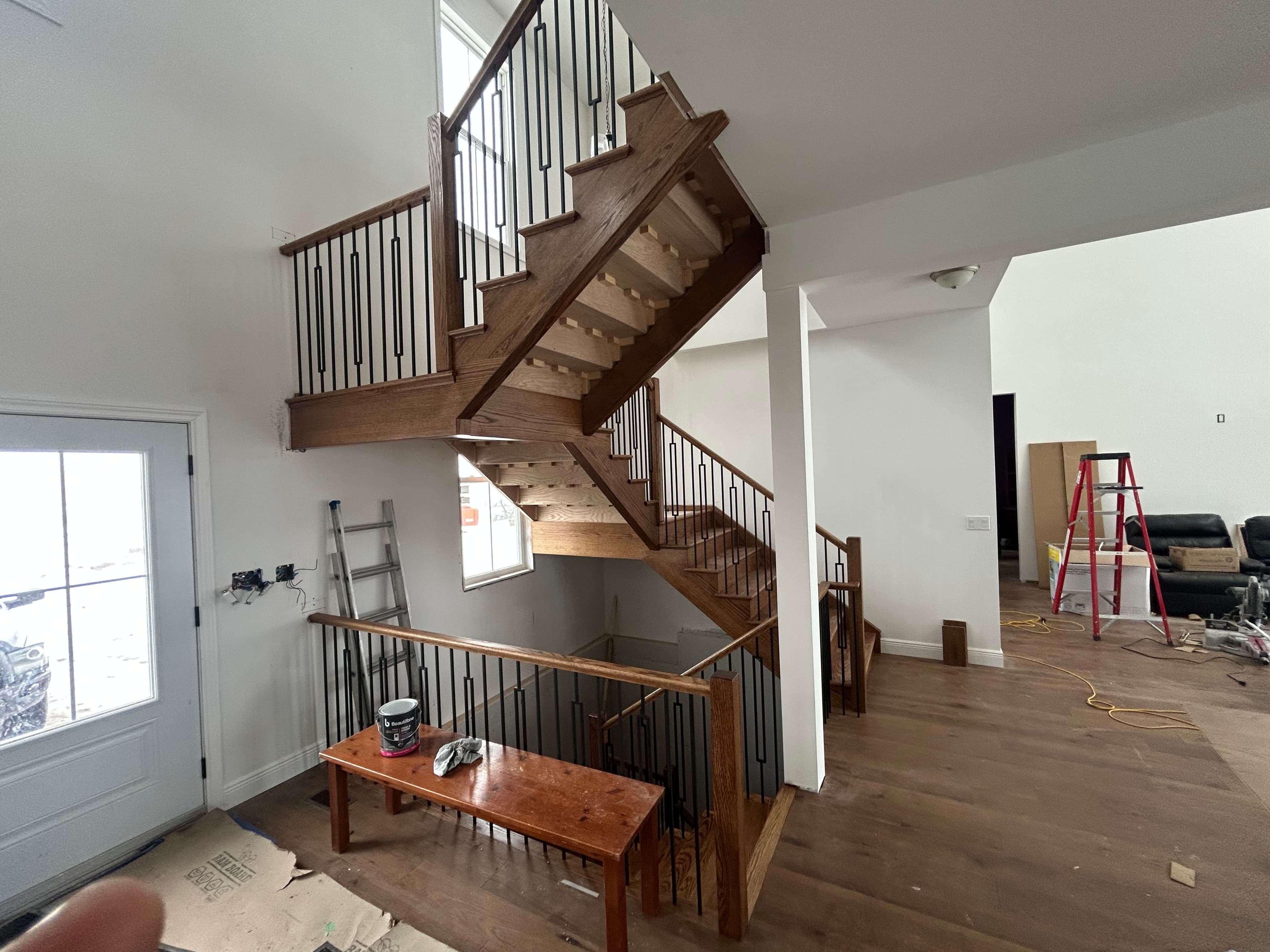 Open stair structure with exposed underside, stained wood, and black balusters.